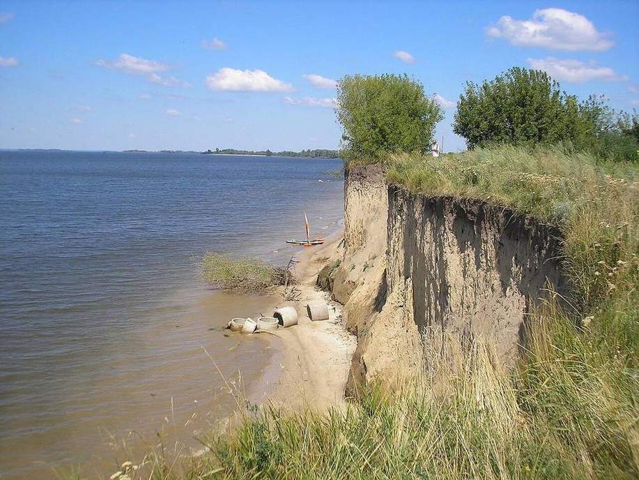 A deep gully cut into a soil slope.